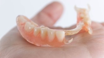 Hand holding a partial denture
