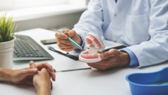 Dentist pointing to implant denture model